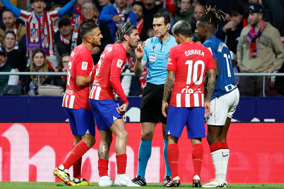 Jugadores del Atlético de Madrid conversan con el árbitro Martínez Munuera durante un partido de la Liga española. EFE/Mariscal