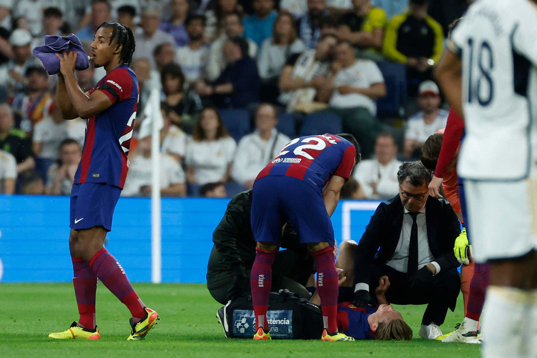 El centrocampista neerlandés del FC Barcelona Frenkie de Jong (abajo) es atendido por los servicios médicos en el estadio Santiago Bernabéu de Madrid en foto de archivo de Juanjo Martín. EFE