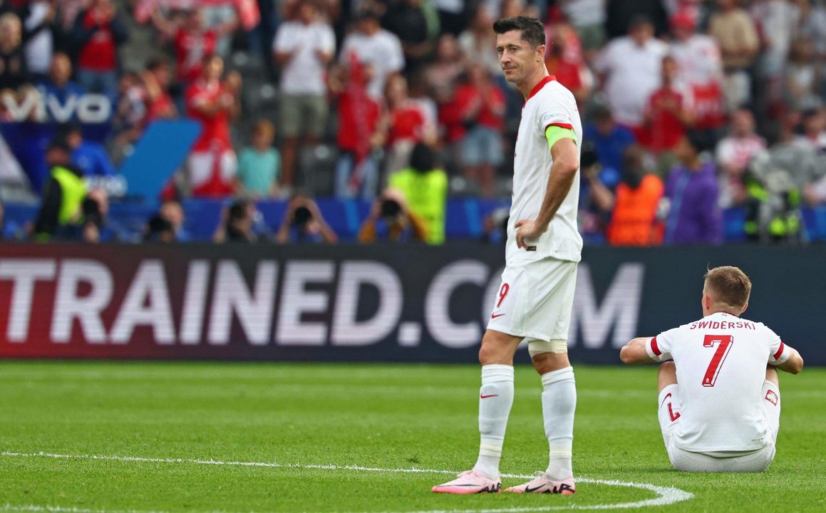 El delantero polaco Robert Lewandowski (I) y Karol Swiderski se lamentan tras la segunda derrota de Polonia en el torneo tras el partido del grupo D que han jugado Polonia y Austria en el Olímpico de Berlín, Alemania. EFE/EPA/HANNIBAL HANSCHKE