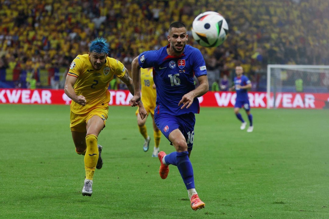 El defensa eslovaco David Hancko (c) y el rumano Andrei Ratiu buscan el balón durante el partido del grupo E que han jugado Eslovaquia y Rumanía en Fránkfort, Alemania. EFE/EPA/MOHAMMED BADRA