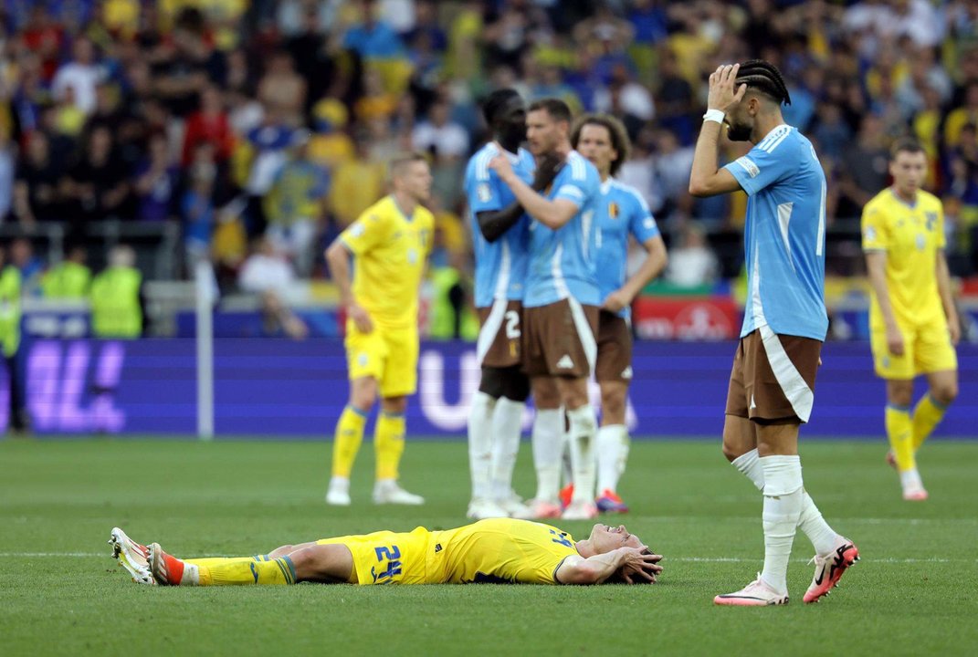 El ucraniano Oleksandr Svatok (tendido en el césped) y varios jugadores belgas durante el  partido del grupo E que han jugado Bélgica y Ucrania en Stuttgart, Alemania. EFE/EPA/RONALD WITTEK