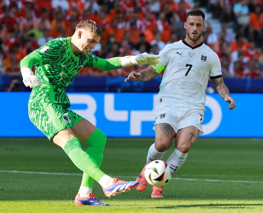 El portero neerlandés Bart Verbruggen (L) sufre la presión del delantero austriaco Marko Arnautovic en Berlin. EFE/EPA/CLEMENS BILAN