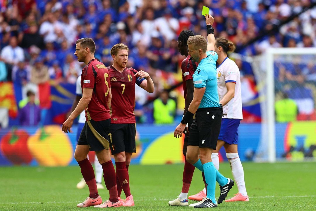 El árbitro sueco Glenn Nyberg (2-d) muestra amarilla al francés Adrien Rabiot durante el partido de octavos que han jugado Francia y Bélgica en Düsseldorf, Alemania. EFE/EPA/FILIP SINGER