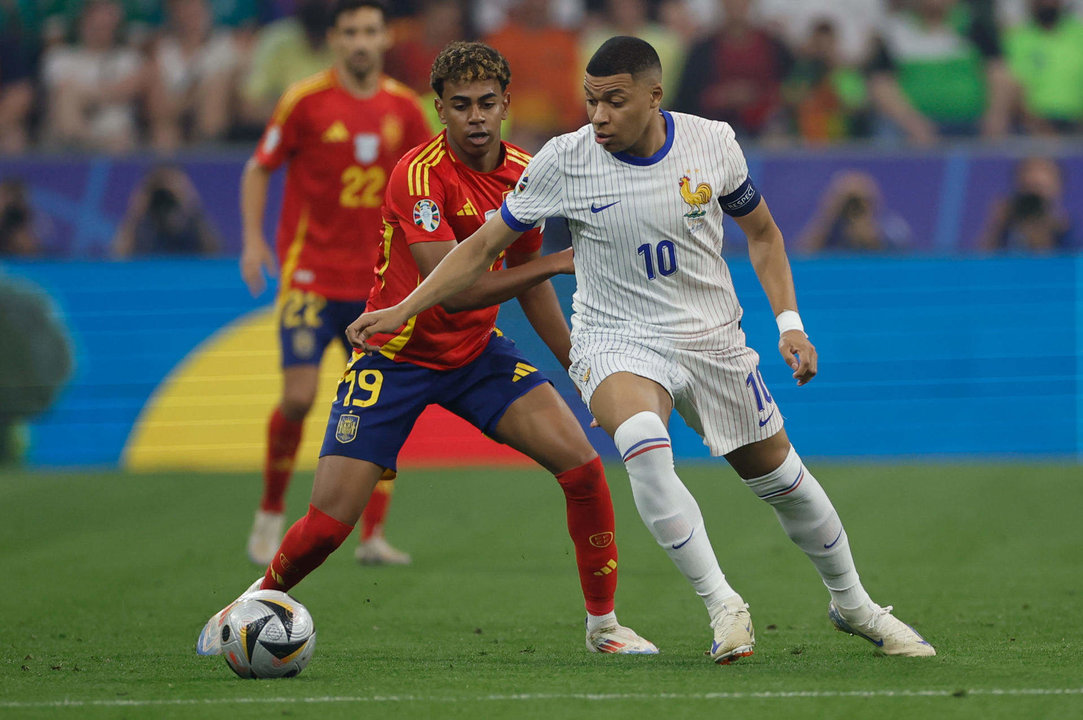 El delantero de la selección española Lamine Yamal (i) pelea un balón con Kylian Mbappé, de Francia, durante el partido de semifinales de la Eurocopa de fútbol que España y Francia disputaron en Múnich. EFE/Alberto Estévez